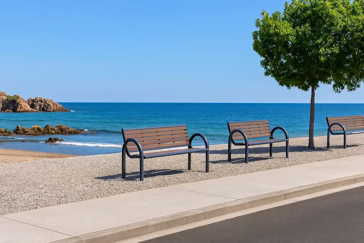 Row of steel-framed park benches with wooden slats along a seaside promenade showing consistent seat height